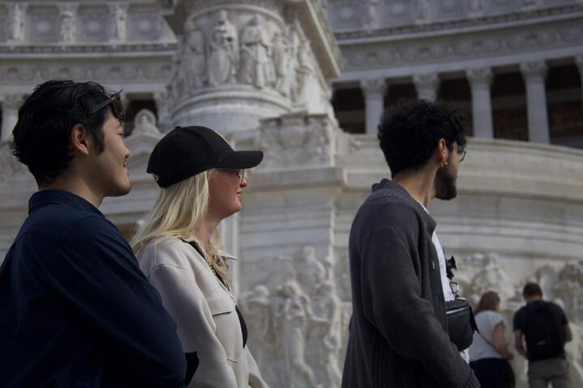 dos homes i una dona drets davant d'un edifici