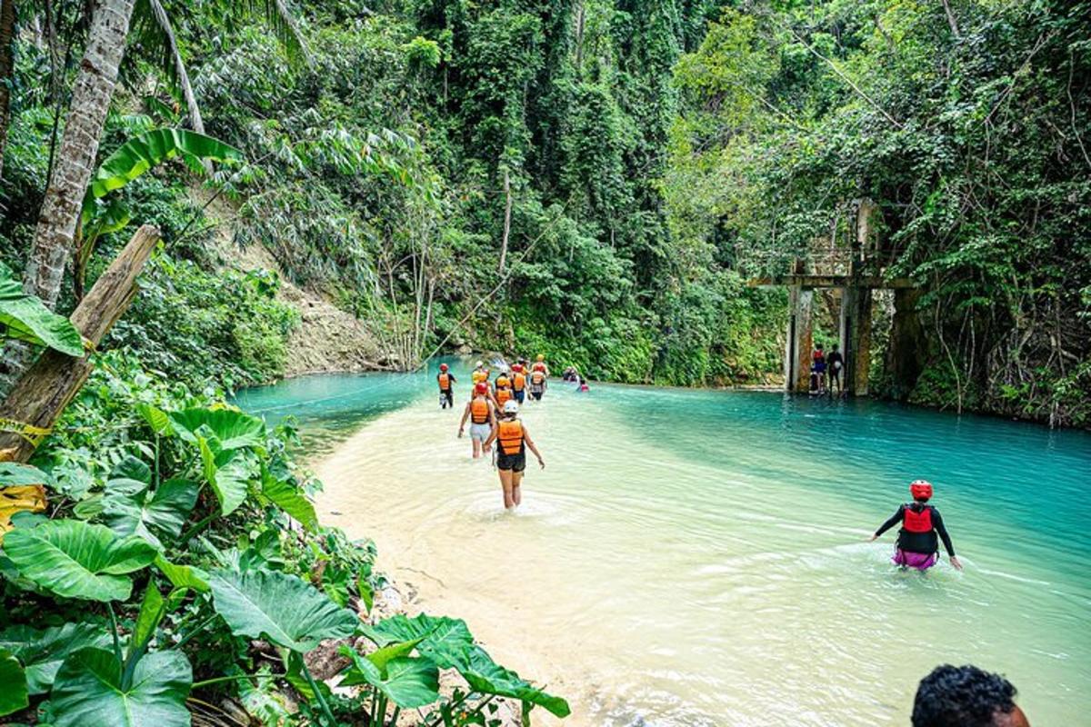um grupo de pessoas atravessando um rio na selva