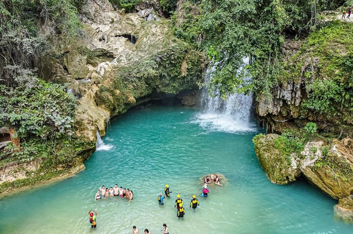 un gruppo di persone in un fiume con una cascata