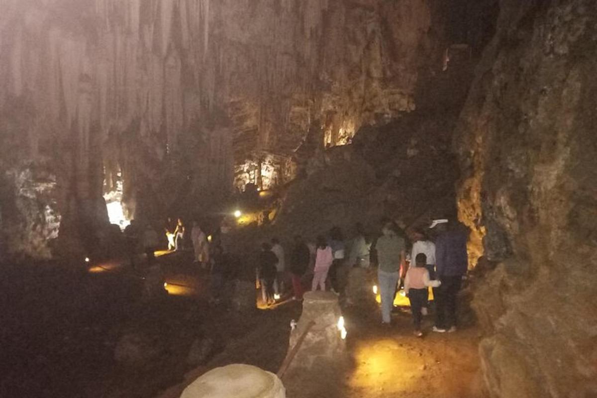 un grup de persones caminant per una cova de nit