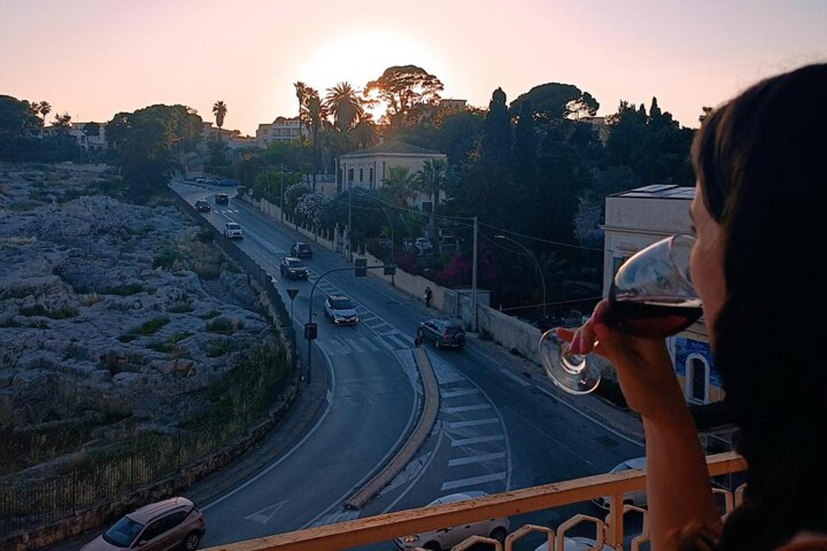 Μια γυναίκα πίνει ένα ποτήρι κρασί σε ένα μπαλκόνι