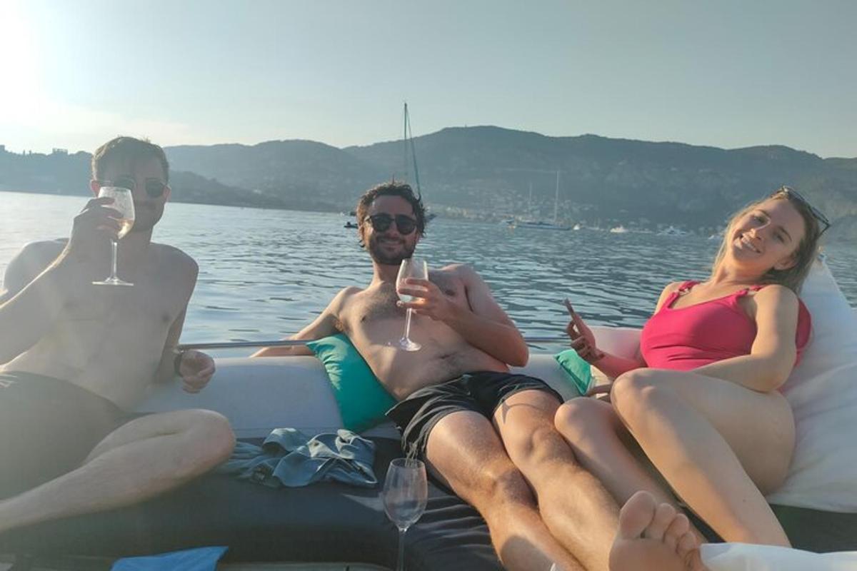 trei persoane stând pe o barcă cu pahare de vin