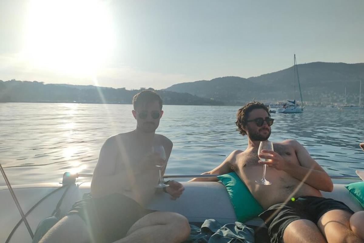 dva muži sedící v lodi se sklenkou vína