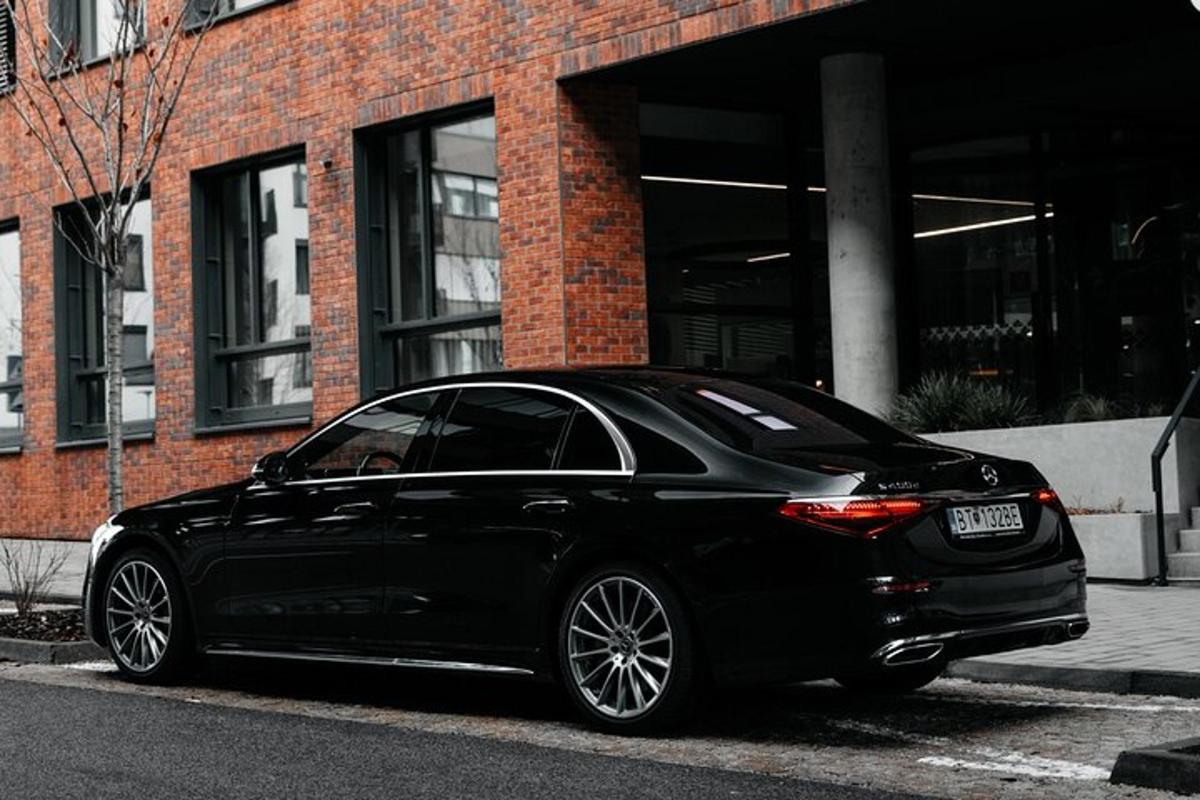 a black car parked in front of a brick building