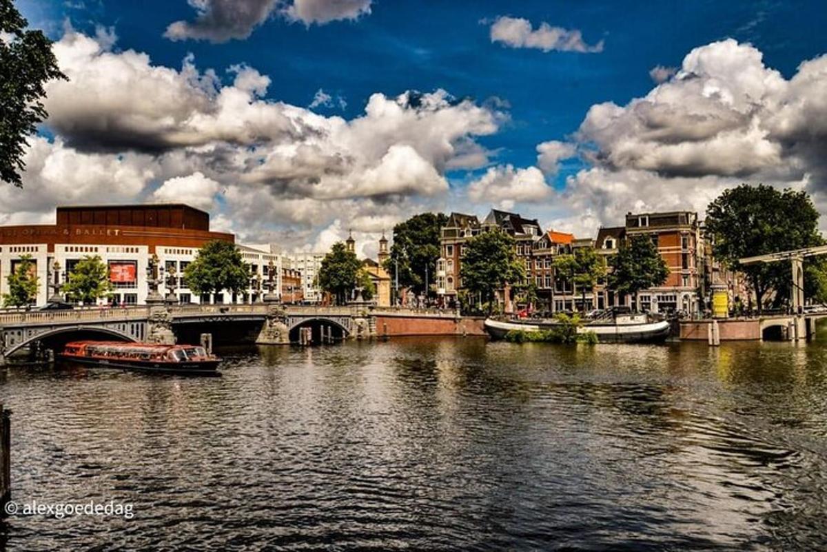 a river with buildings and a bridge with boats on it