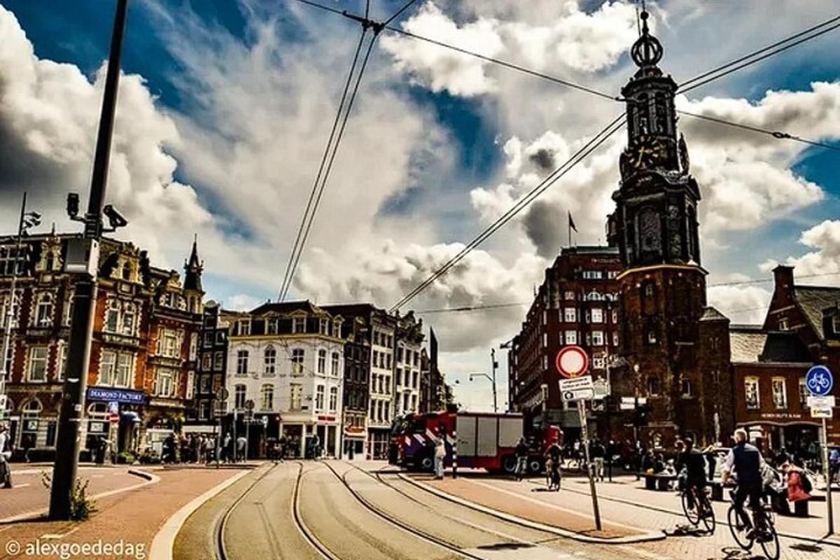 a city street with a clock tower and people riding bikes