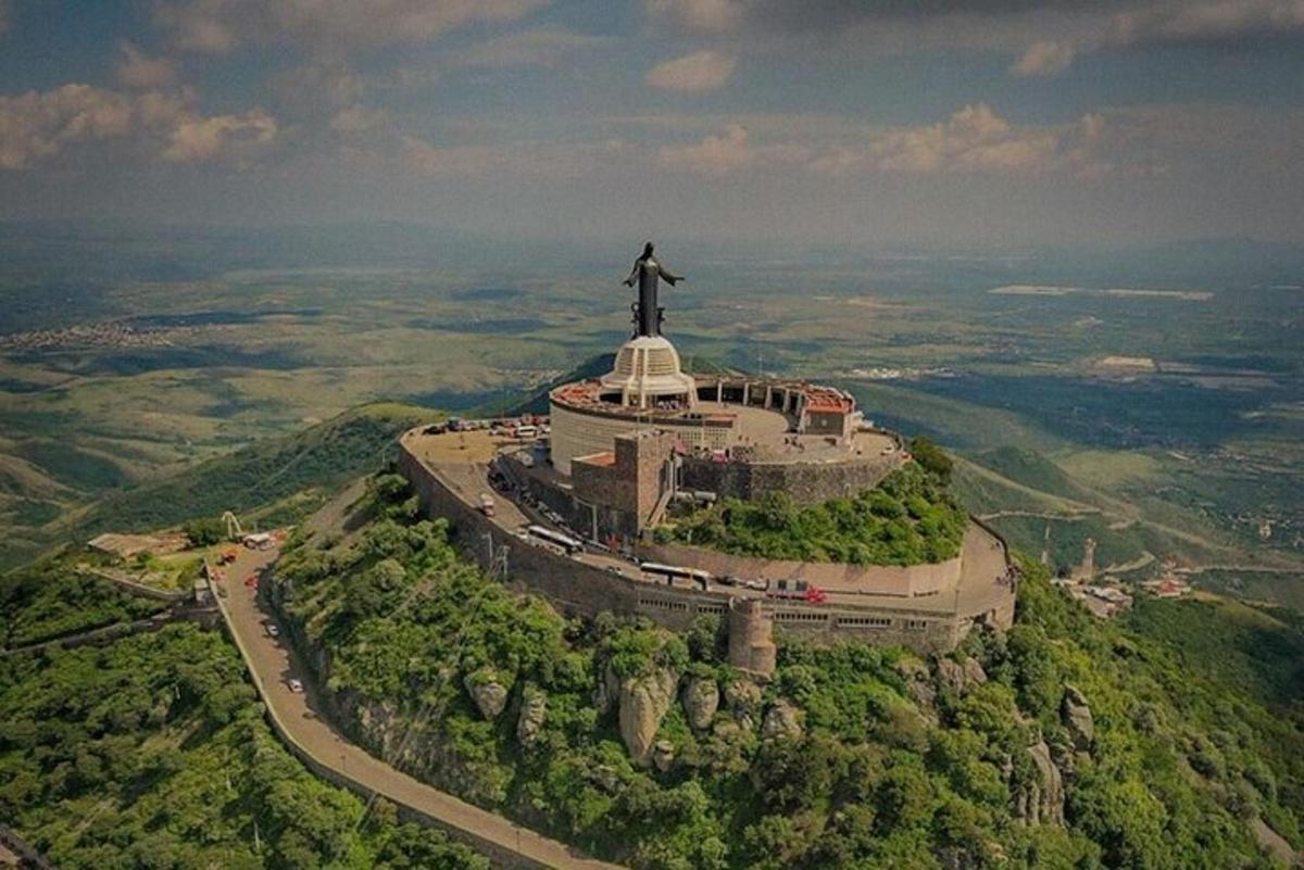 an aerial view of a statue on top of a mountain