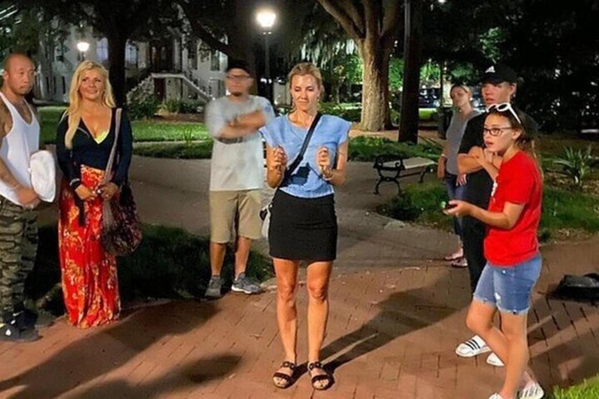 a group of people standing around in a park