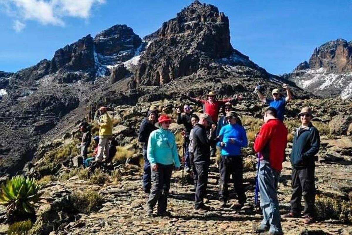 hópur fólks sem stendur uppi á fjallstindi