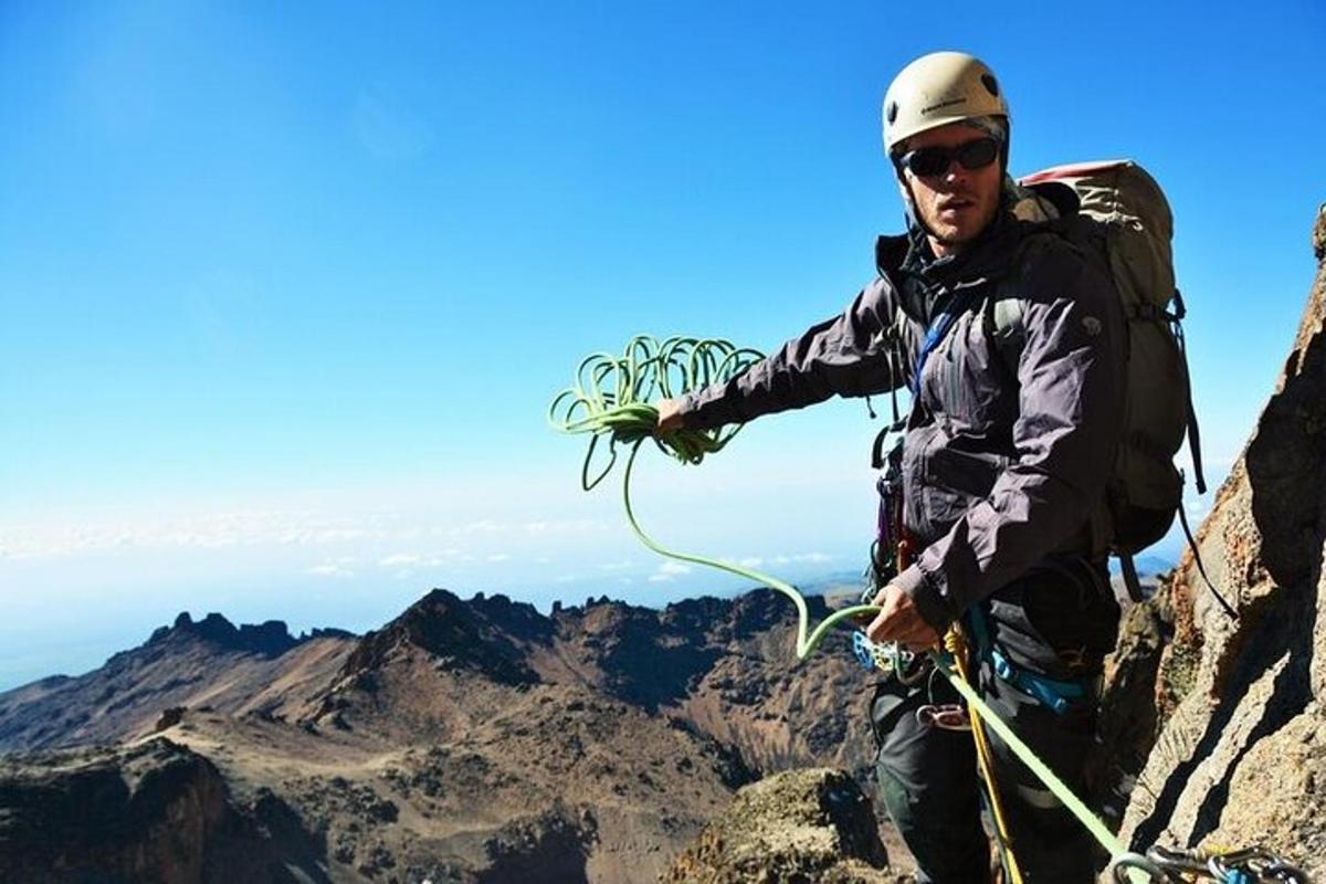 un home que sosté una corda al cim d'una muntanya