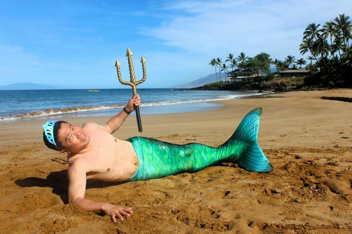 ビーチで人魚の衣装を着た男性