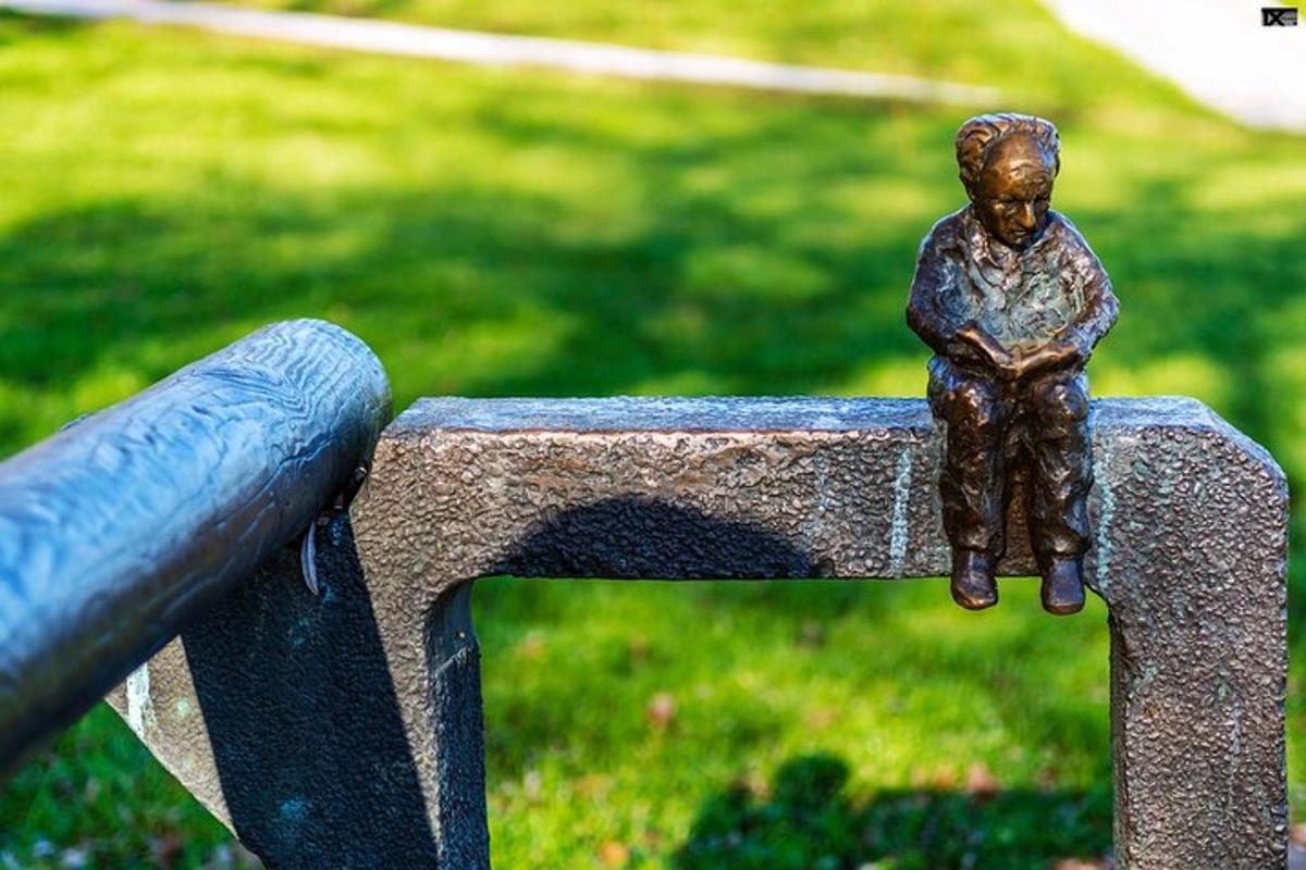 isang estatwa ng isang batang lalaki na nakaupo sa tuktok ng isang monumento