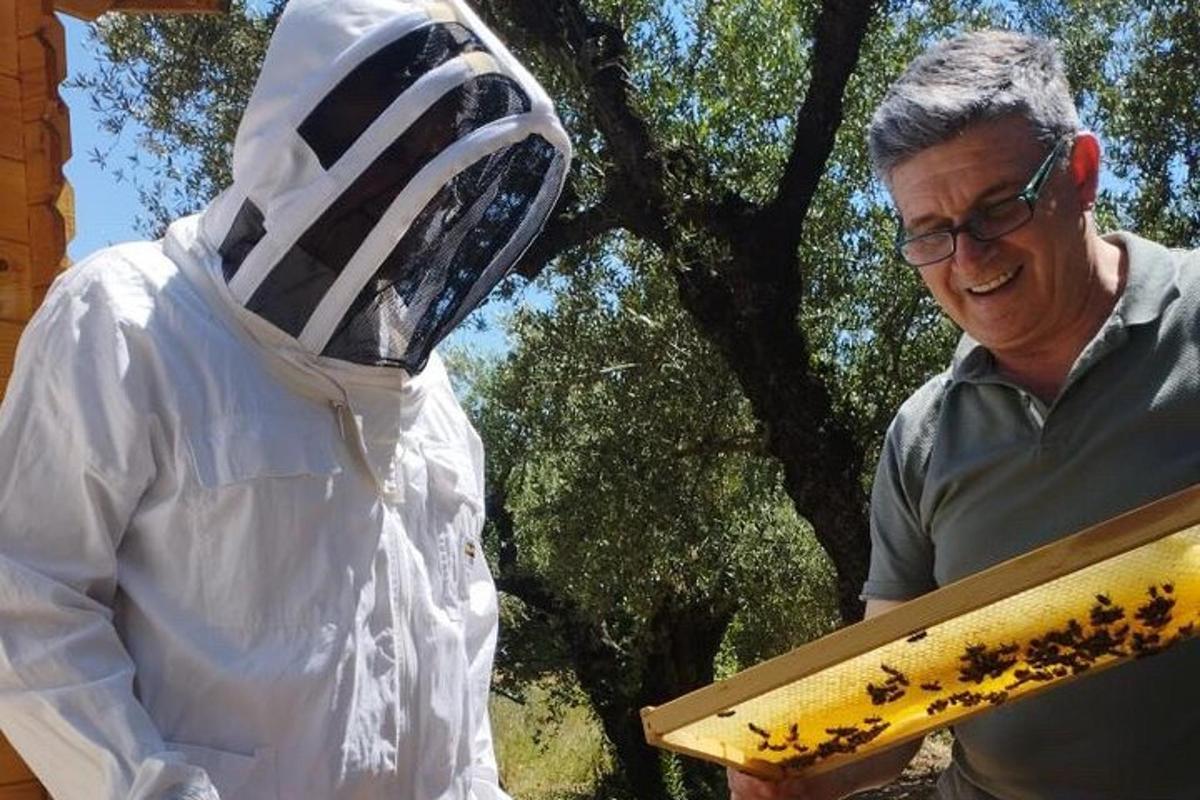 muž stojící vedle sochy osoby držící kus dřeva