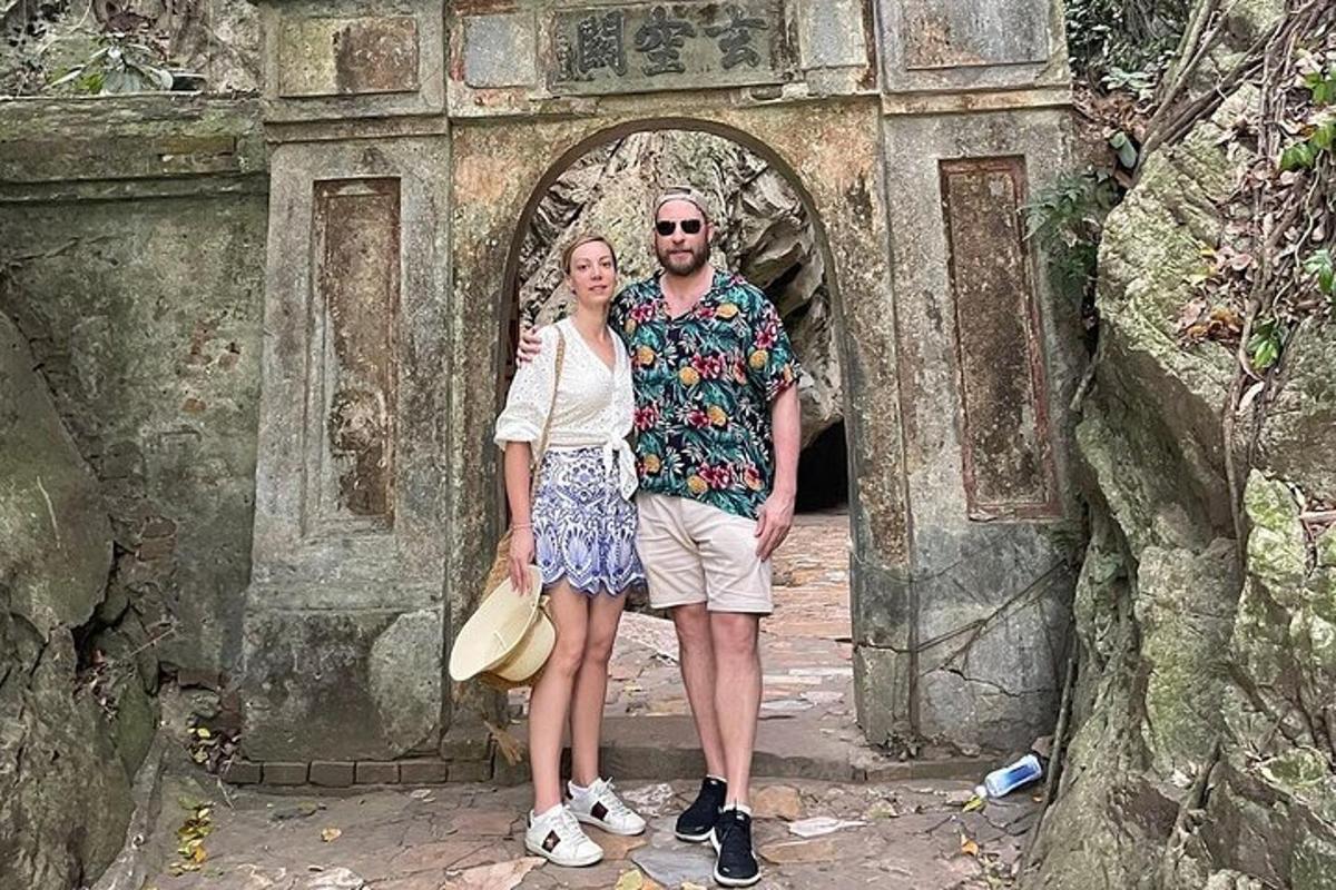 um homem e uma mulher em pé em frente a um arco