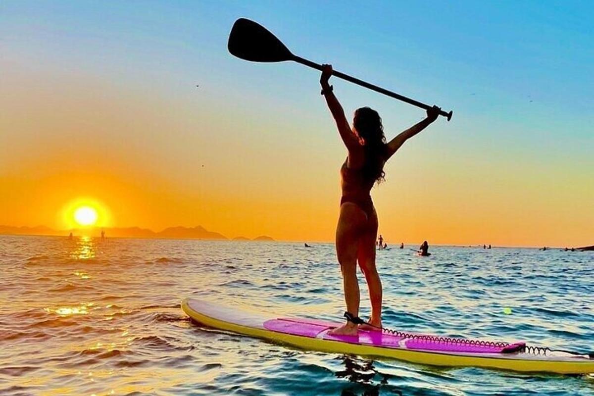 žena stojící na paddleboardu v oceánu
