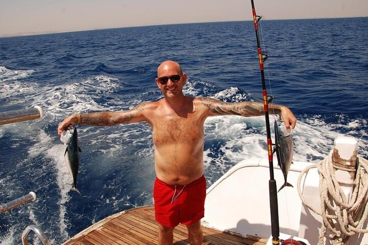 a man standing on a boat holding a fish