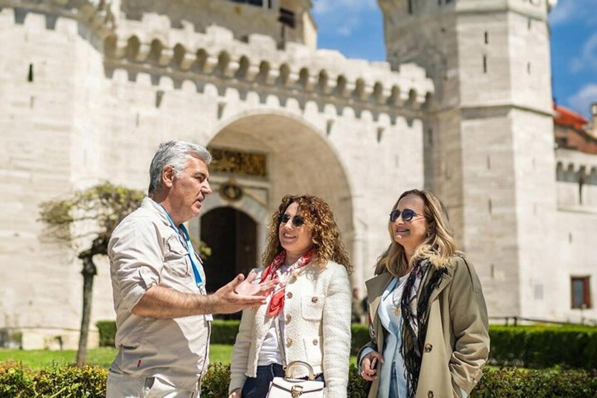 un home i dues dones drets davant d'un edifici