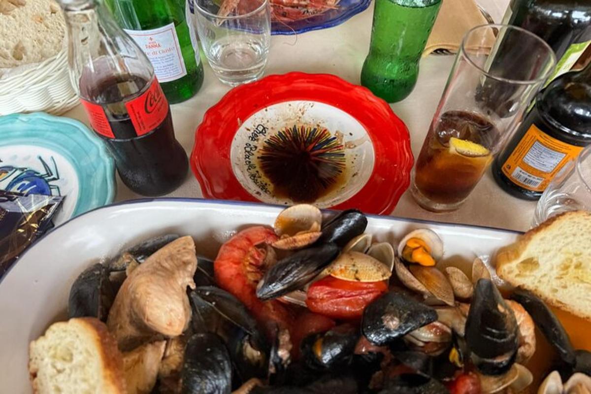 isang mesa na may isang plato ng pagkain na may tahong at tinapay