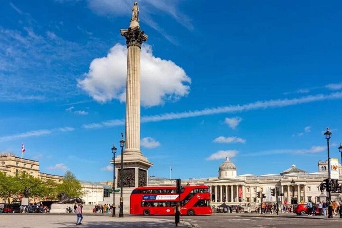 červený dvoupatrový autobus před památníkem