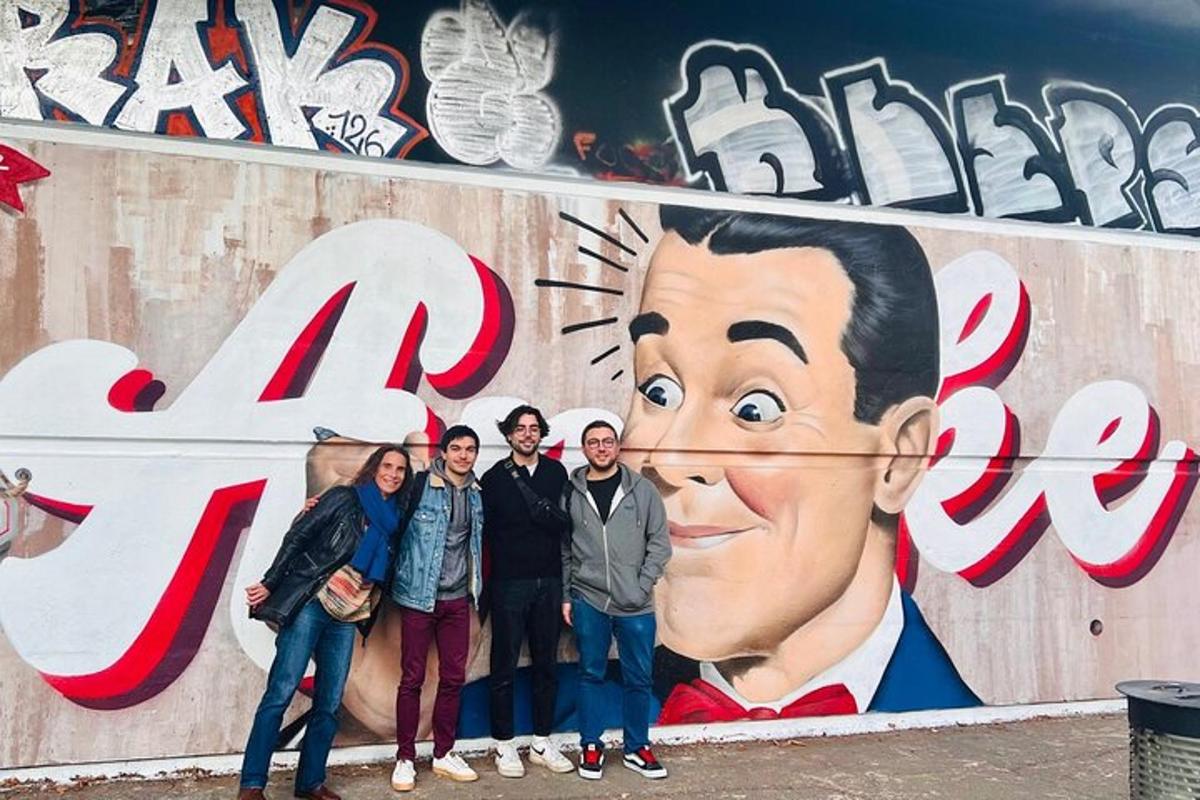 Un grupo de personas de pie frente a un mural.