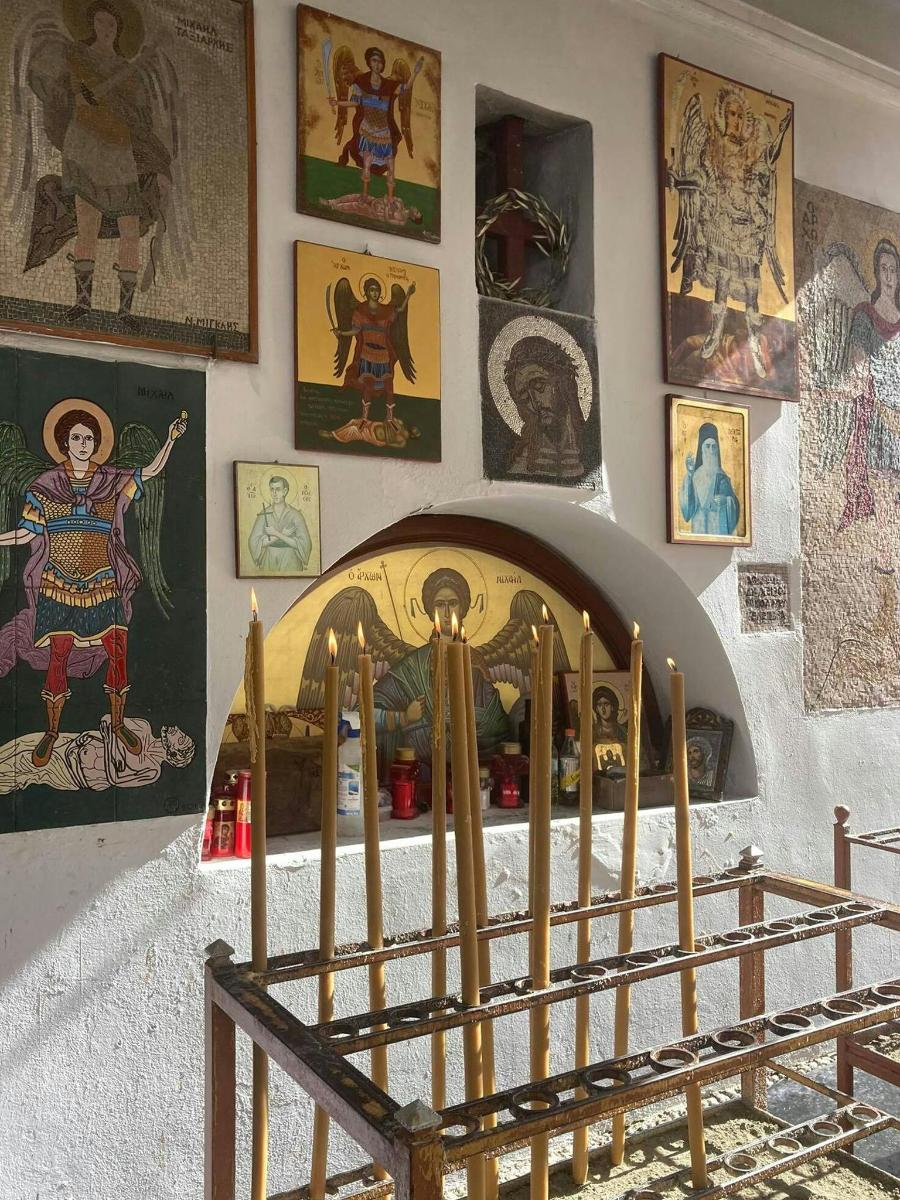 ένα δωμάτιο με έναν τοίχο γεμάτο πίνακες και αφίσες