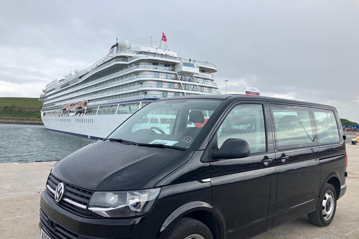 un furgone nero parcheggiato davanti a una nave da crociera