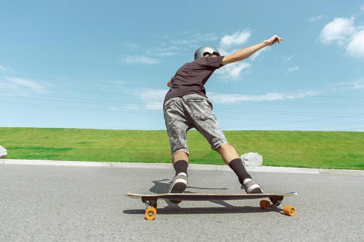en mann som kjører skateboard nedover en vei