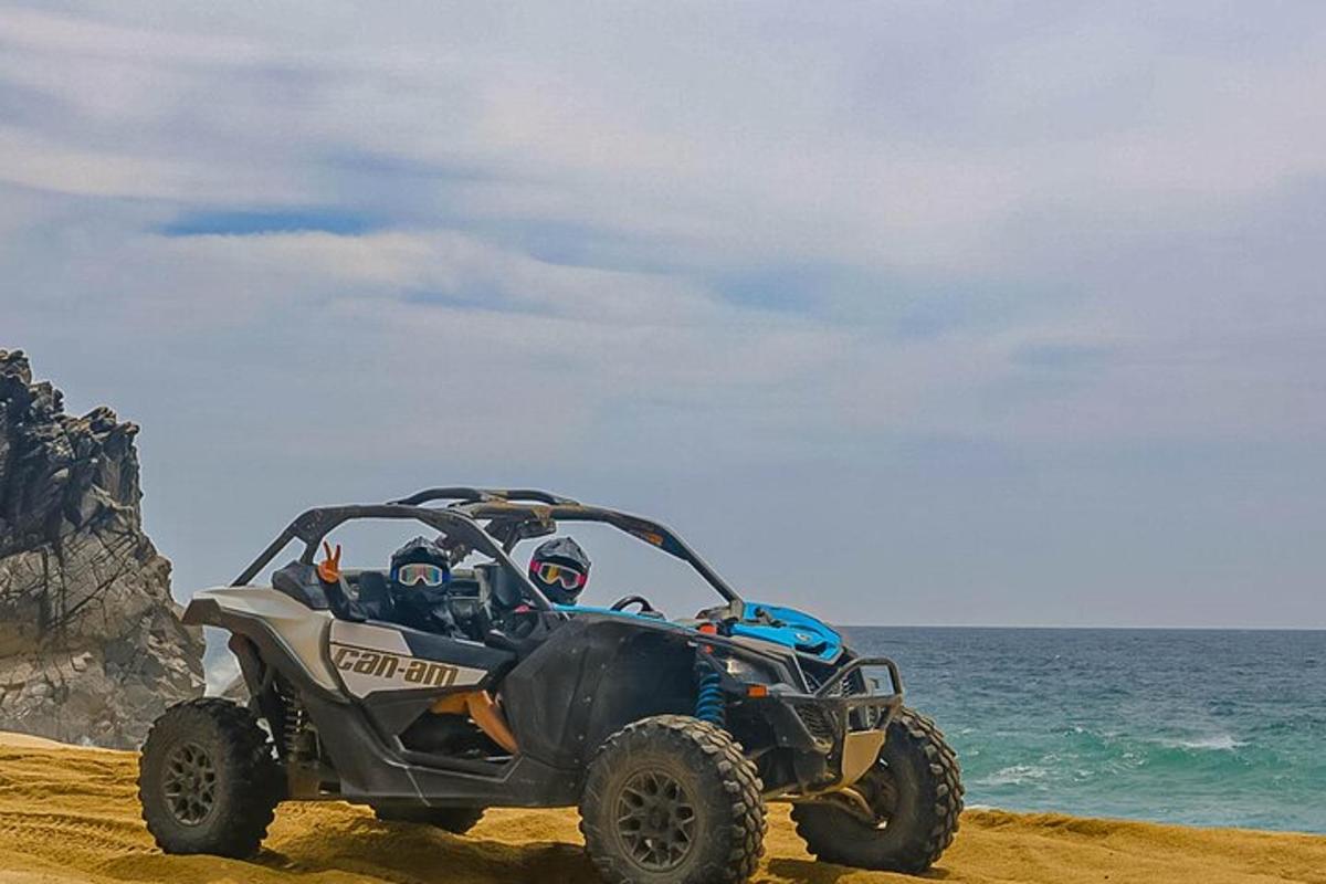 Un vehículo todo terreno estacionado en la playa cerca del océano.