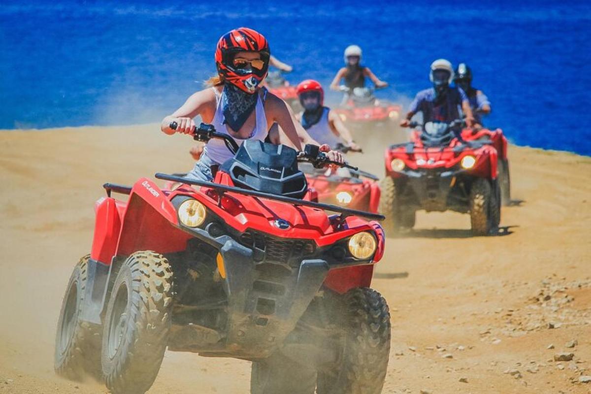 Un grupo de personas conduciendo vehículos todo terreno en la playa.
