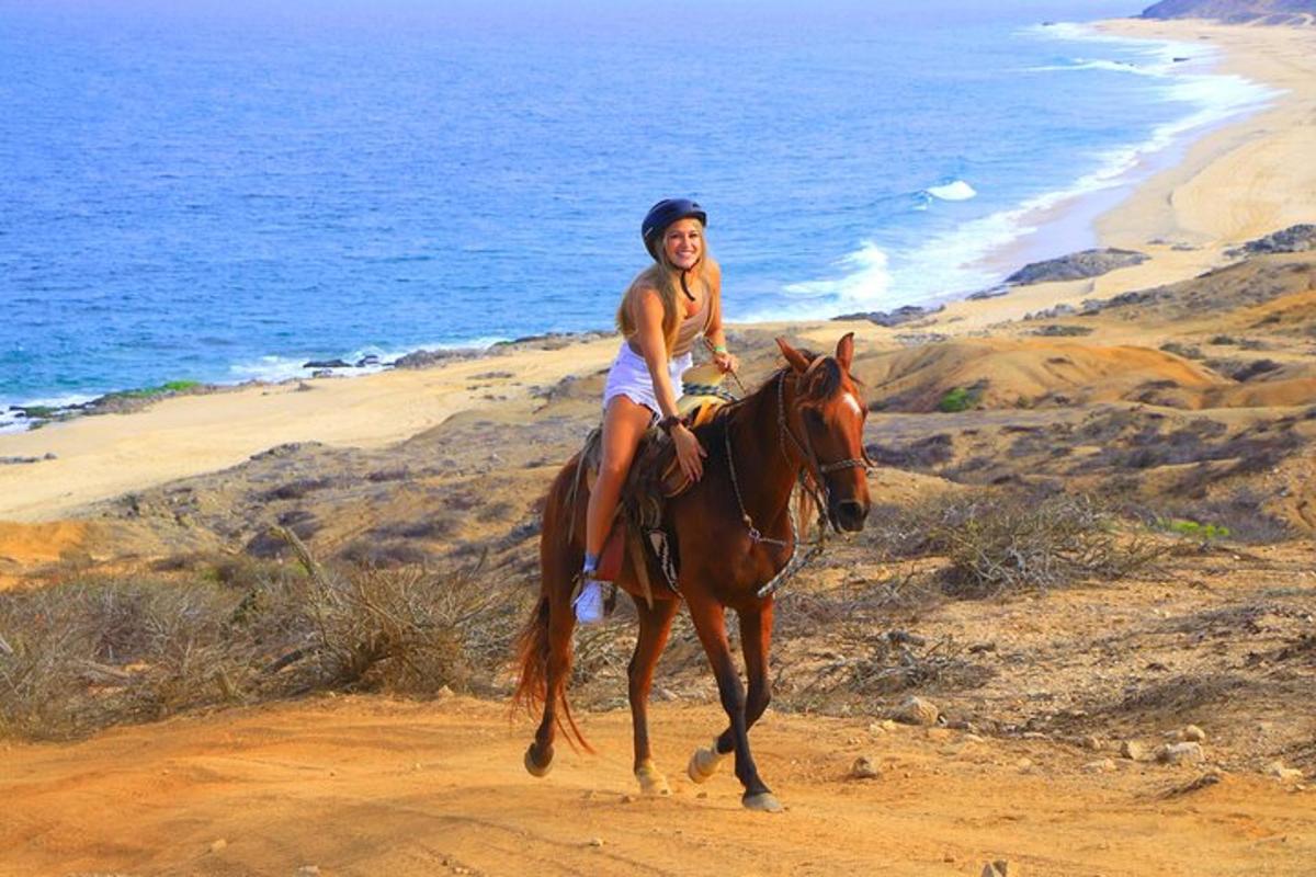 a young woman riding a horse on the beach