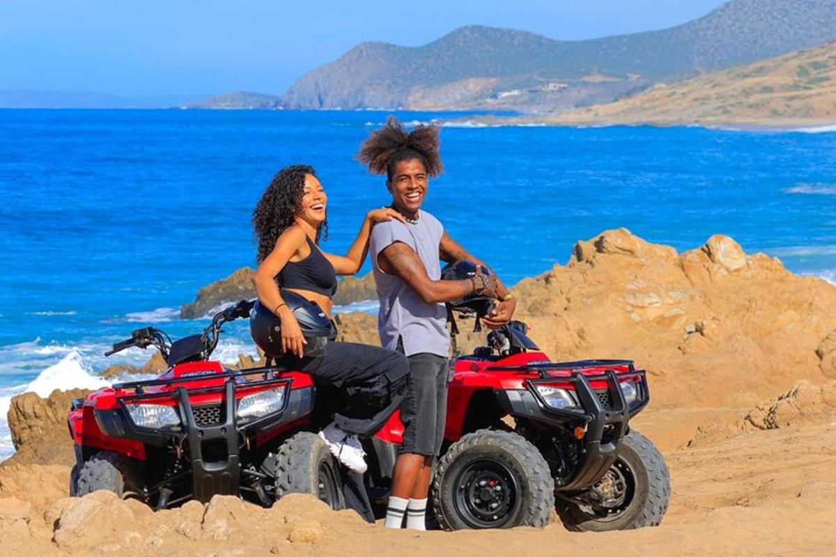 a man and woman sitting on atvs on the beach