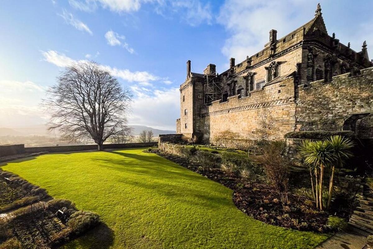 an old castle with a large lawn in front of it