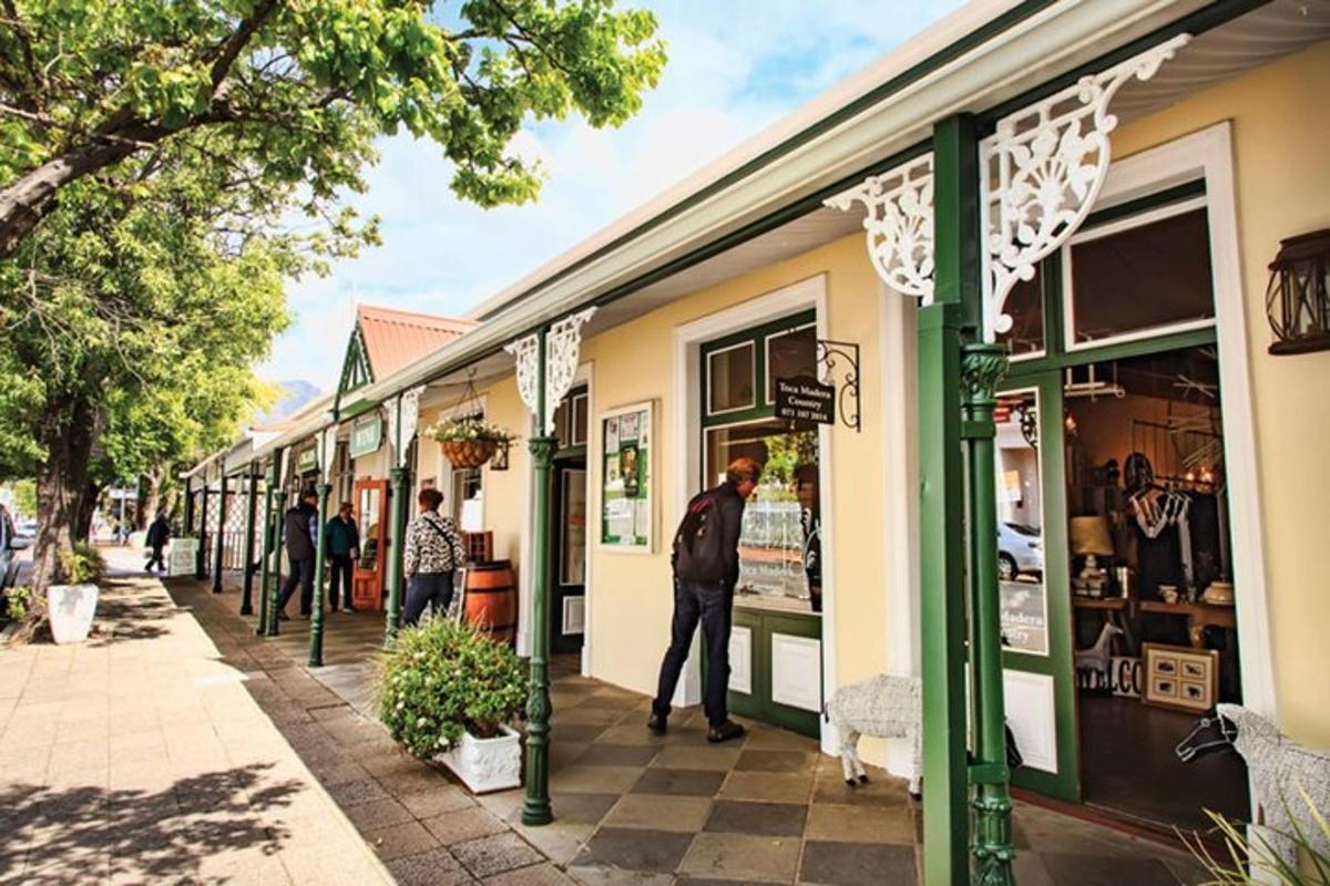 een groep mensen die over een stoep voor een winkel loopt