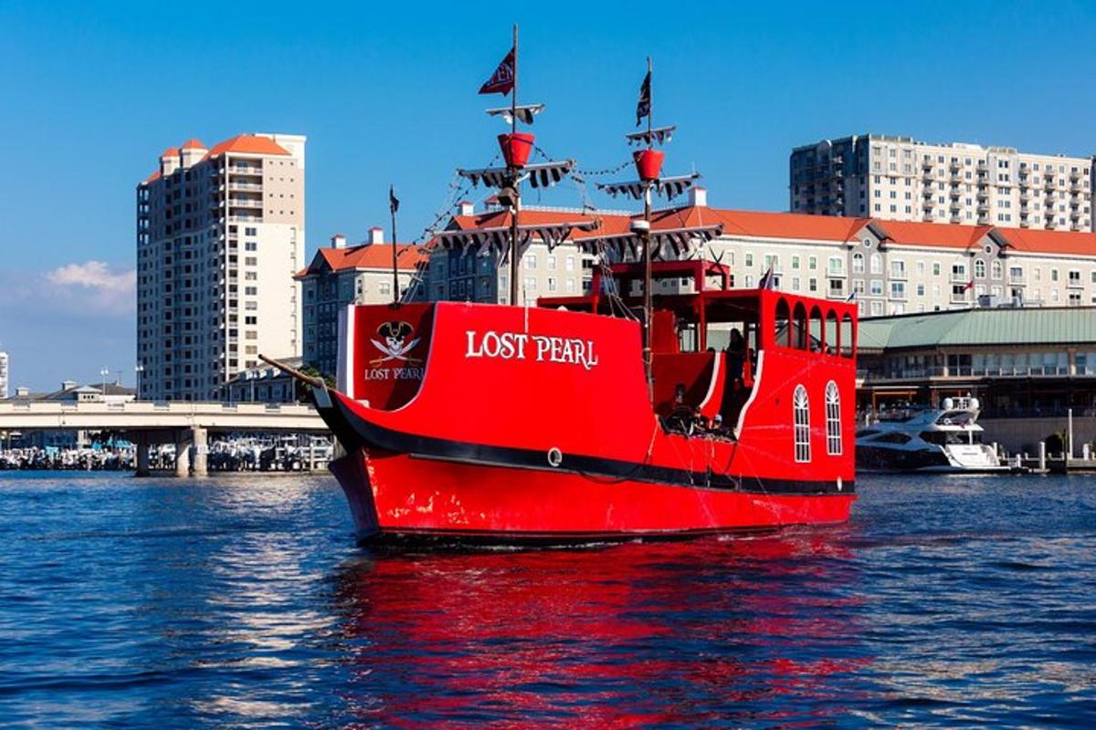 a red boat in the water next to a city