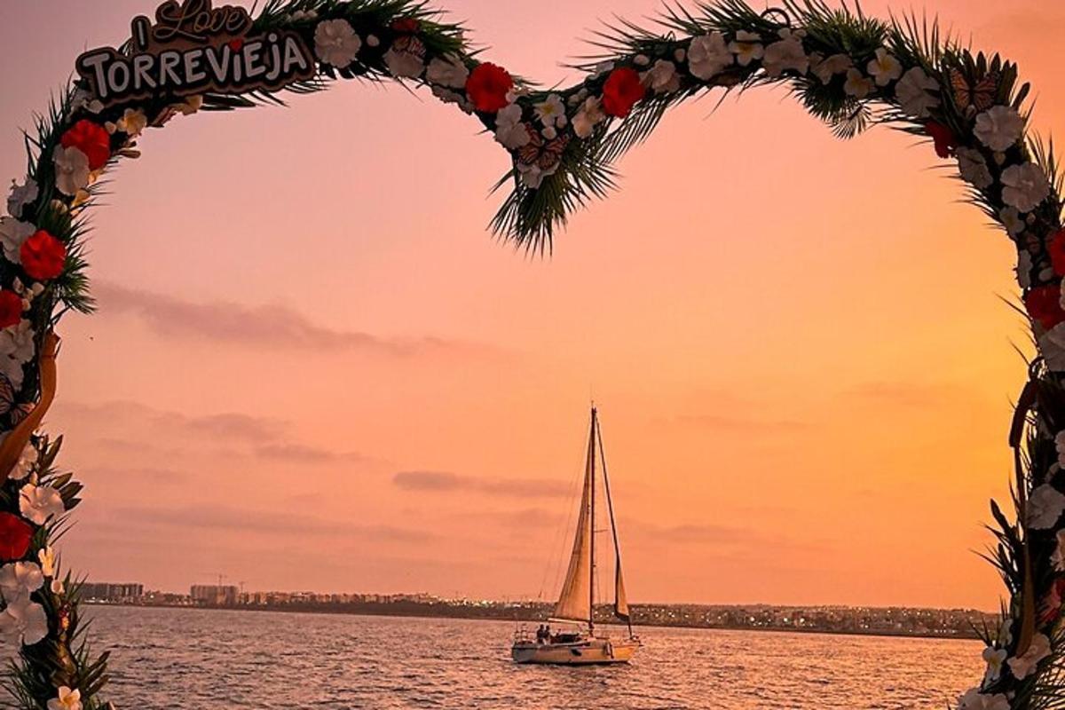 a sailboat in a heart shaped arch over the water