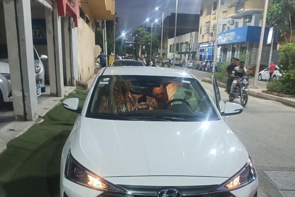muž řídící bílé auto na ulici