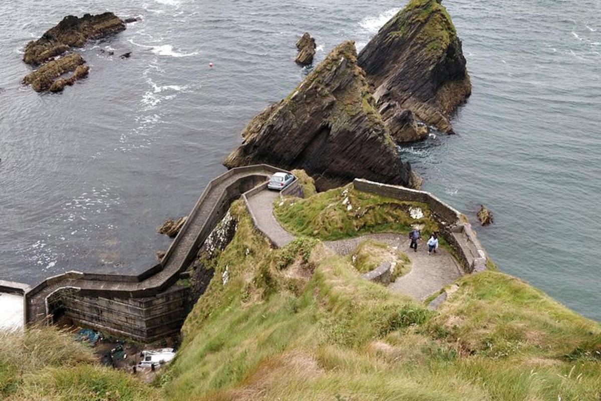 a group of people walking on a cliff near the ocean