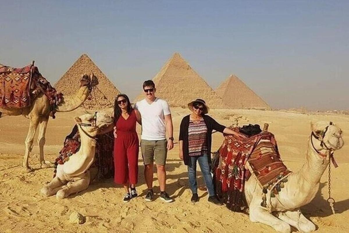 a group of people standing in front of the pyramids
