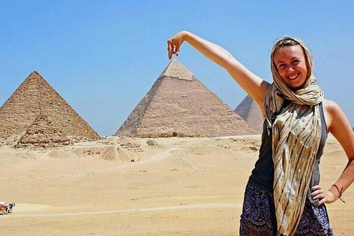 امرأة تقف أمام الأهرامات