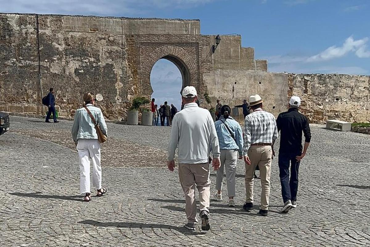 um grupo de pessoas caminhando em frente a um arco