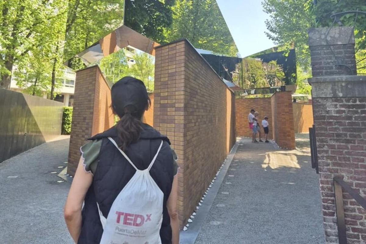 en kvinna som går nerför en trottoar med en vit väska på ryggen