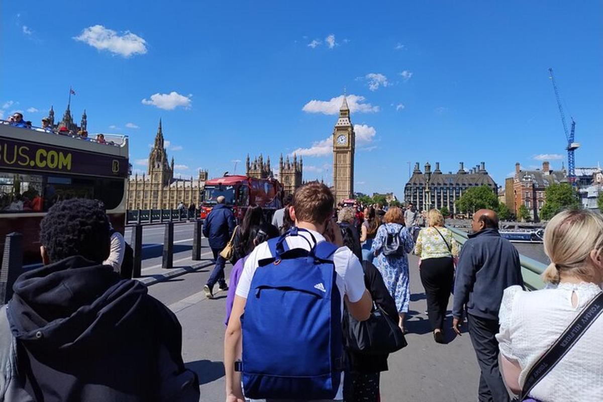 Una multitud de personas caminando por un puente frente al Big Ben.