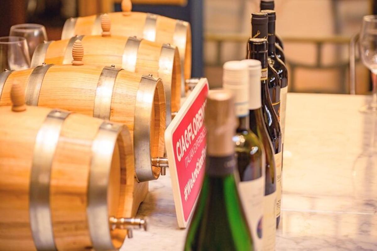 due bottiglie di vino appoggiate su un tavolo accanto alle botti