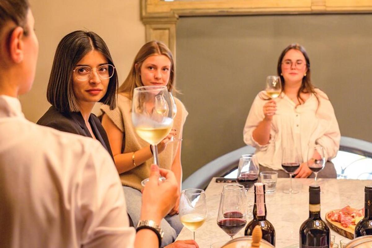 un grup de oameni așezați la o masă cu pahare de vin