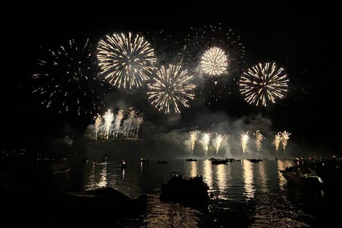 a fireworks display over a body of water with boats
