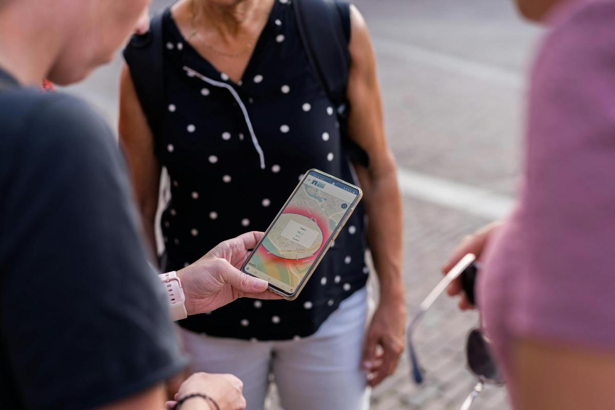 egy nő mobiltelefont tart a kezében