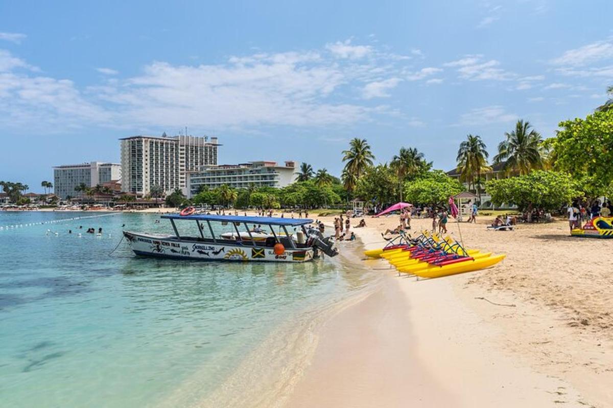Una playa con barcos en el agua y gente en ella.