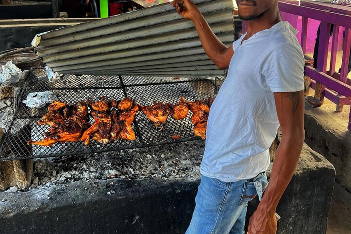 a man standing next to a grill with chickens