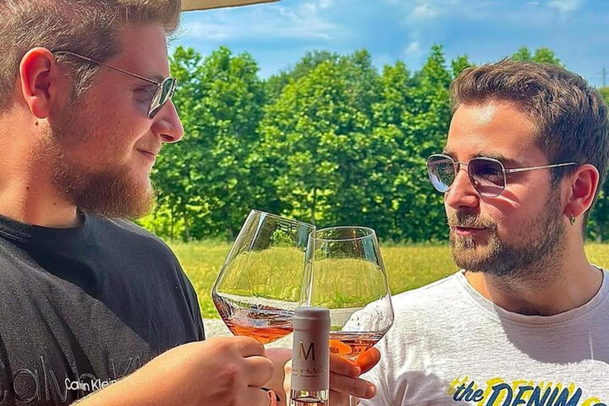due uomini tengono in mano dei bicchieri di vino