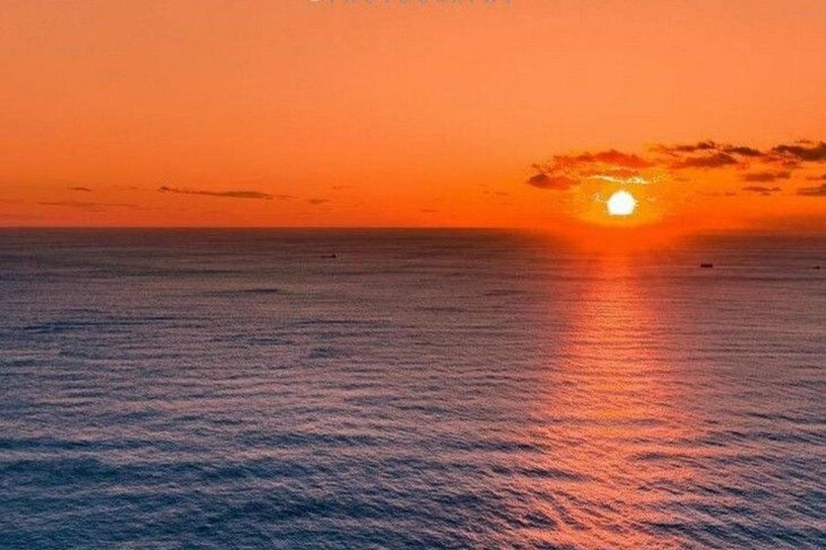 un tramonto sull'oceano con il sole che tramonta
